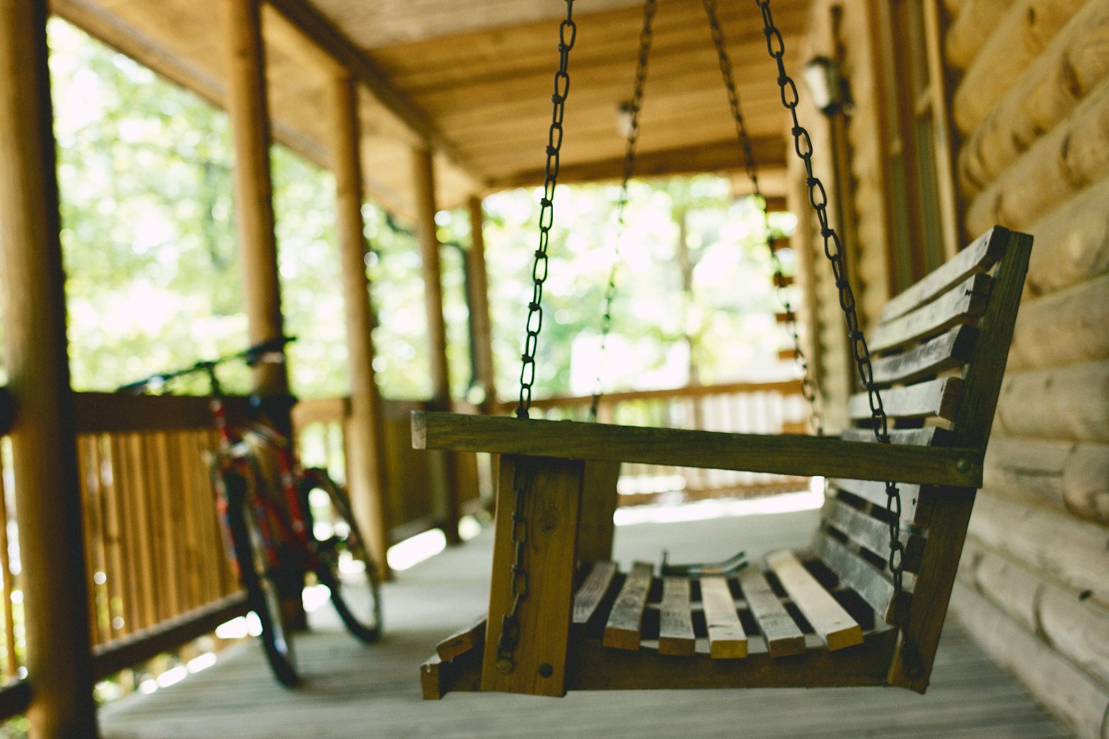 An empty wooden swing on the porch of a house